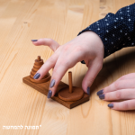 מגדלי האנוי משחק חשיבה מעץ לשחקן יחיד. יד משחקת במשחק